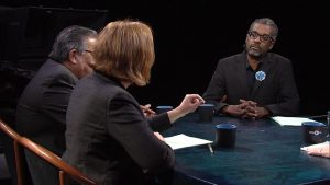 A group of people sitting around a table talking.