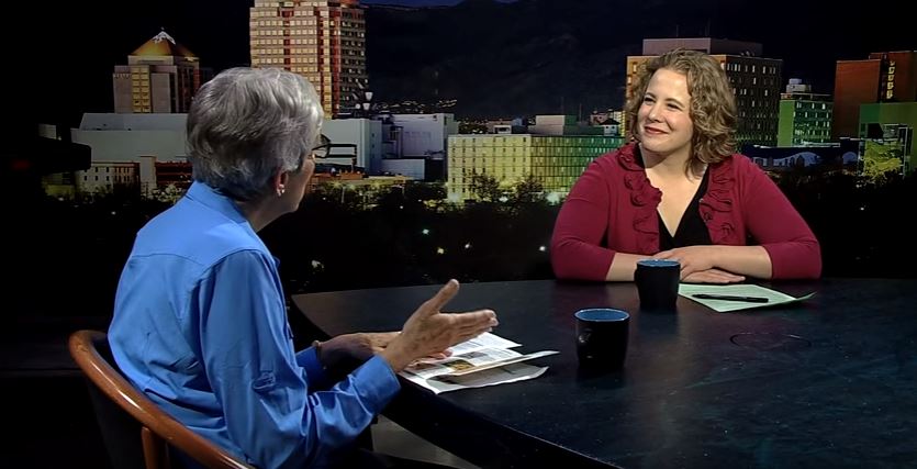 Two people sitting at a table in front of a city.