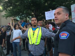 A group of people standing in front of a police officer.