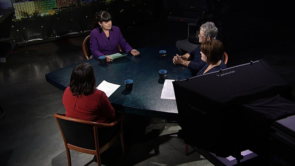 Three women sitting around a table in a television studio.