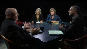 A group of people sitting around a table talking.