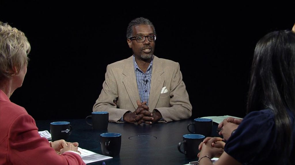 A group of people sitting around a table talking.