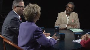A group of people sitting around a table talking.
