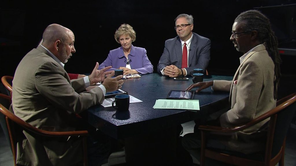 A group of people sitting around a table talking.