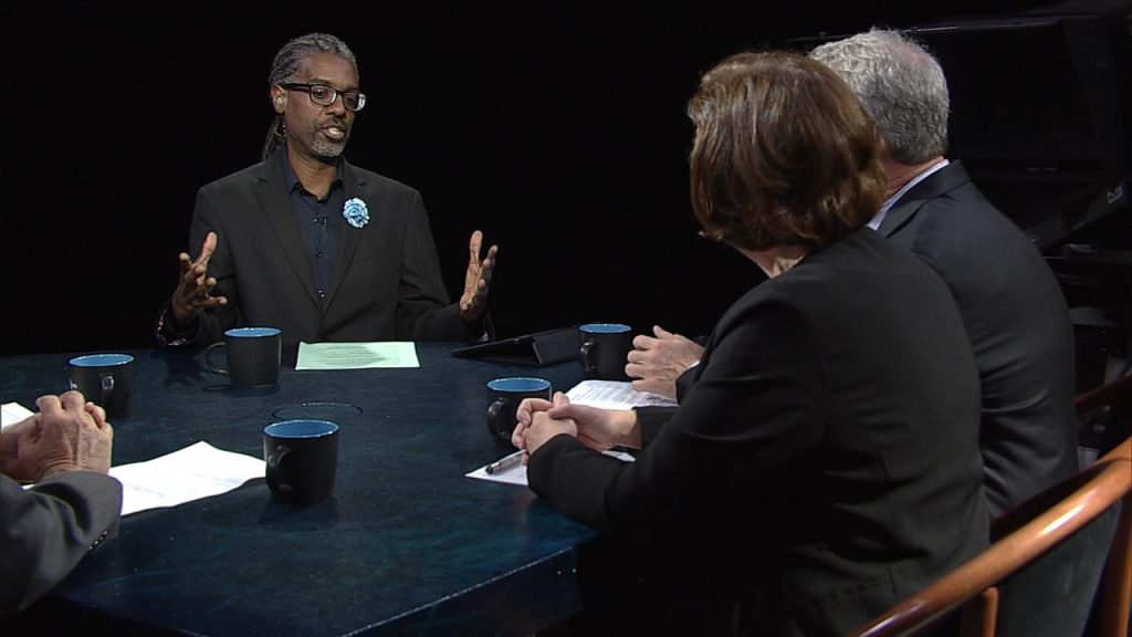 A group of people sitting around a table talking.