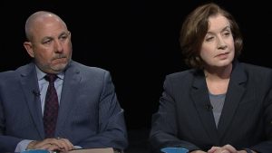 Two people sitting at a table with a cup of coffee.