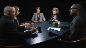 A group of people sitting around a table talking.