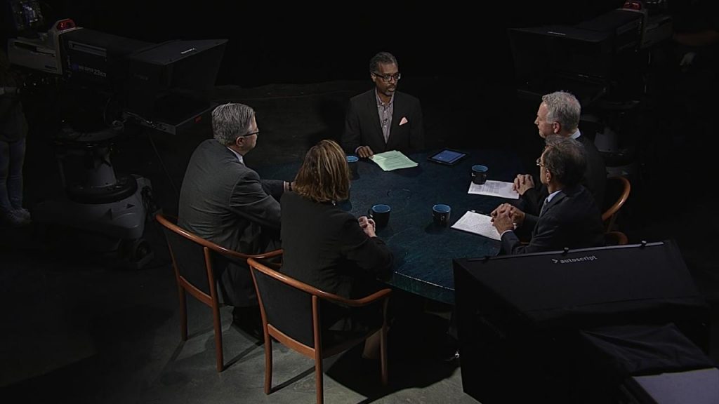 A group of people sitting around a table in a dark room.