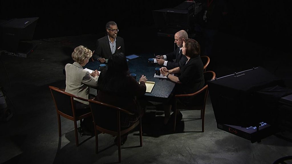 A group of people sitting around a table in a dark room.