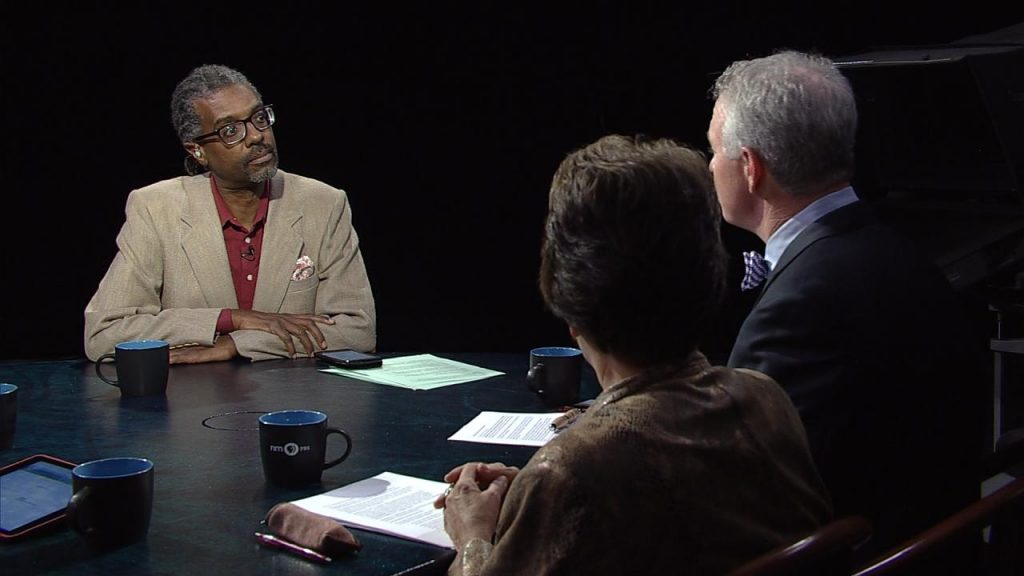 A group of people sitting around a table talking.
