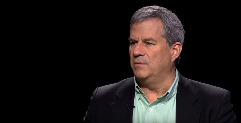 A man in a suit and a green shirt.