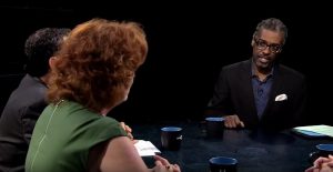 A group of people sitting around a table talking.