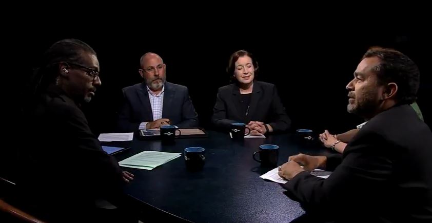 A group of people sitting around a table talking.