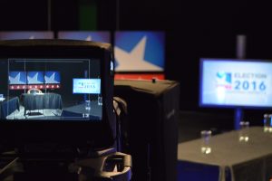 A camera is shown on a table in front of a television.