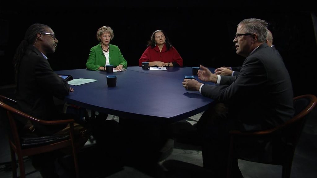 Four people sitting around a table in a dark room.