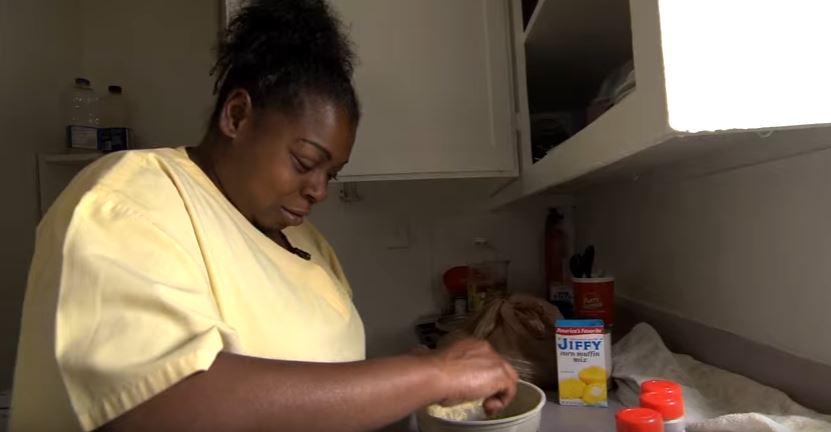 A woman is preparing food in a kitchen.