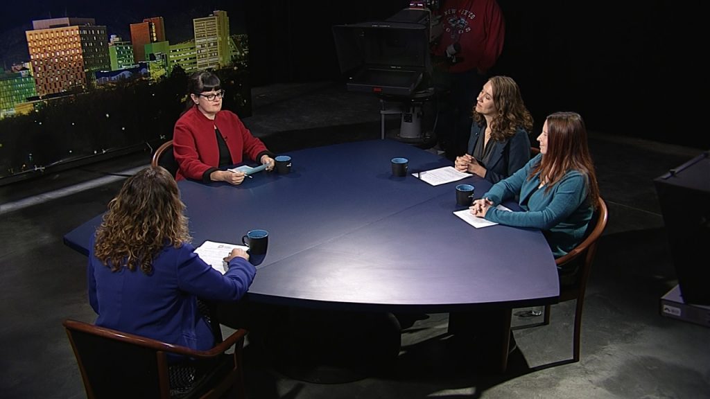 Three women sitting around a table in a television studio.