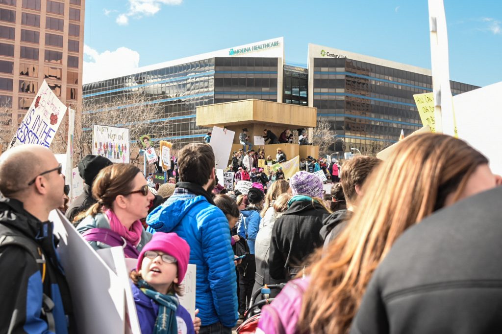 A crowd of people holding signs in front of a building.