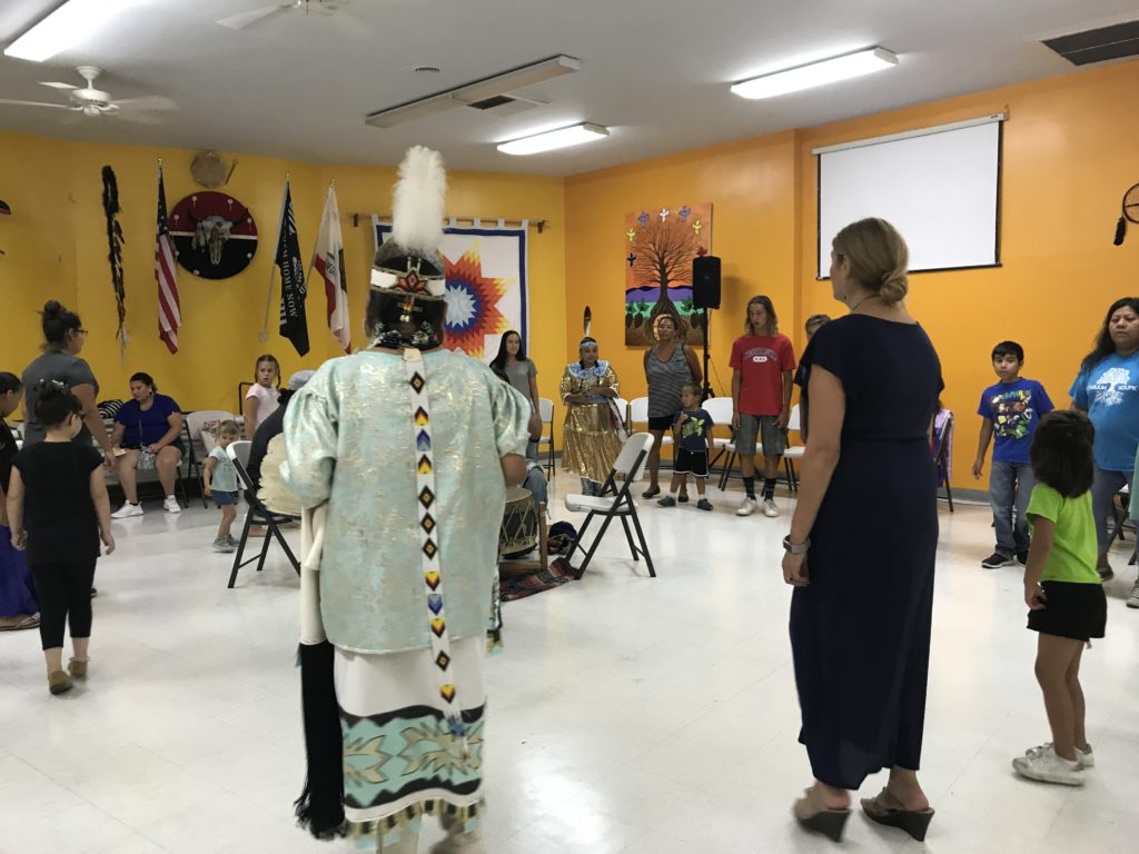 A group of people in native attire in a room.