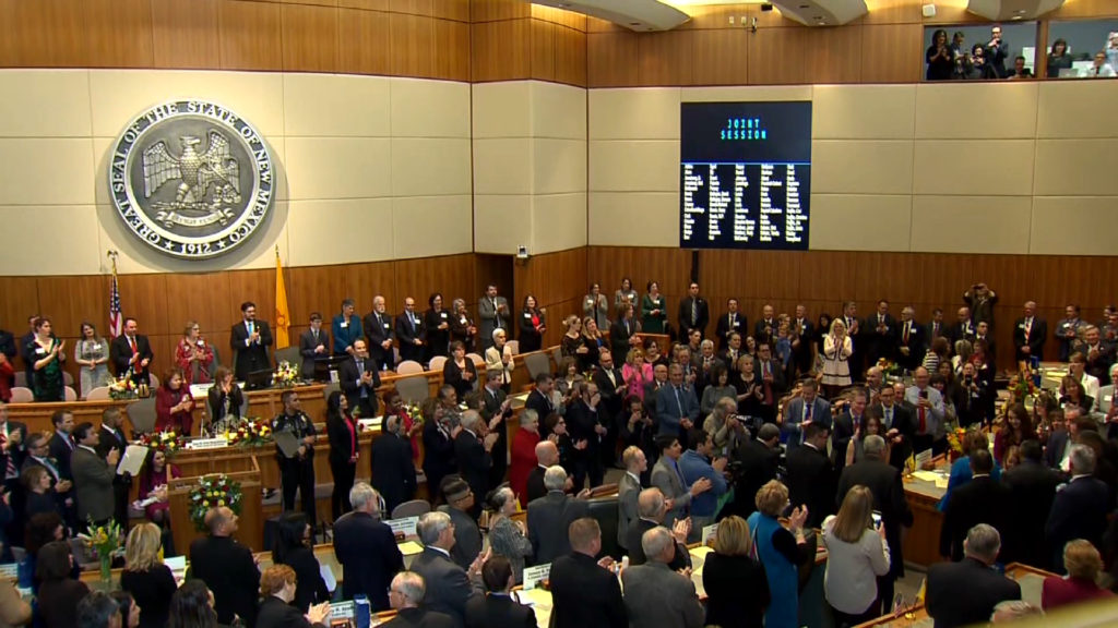 A large group of people standing in a large room.