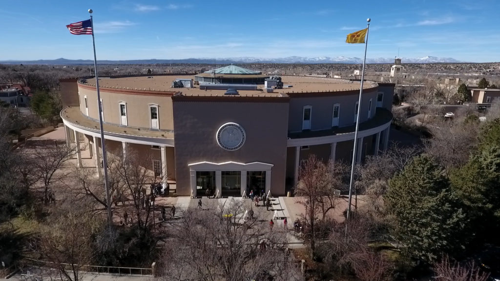 An aerial view of a building with flags flying over it.