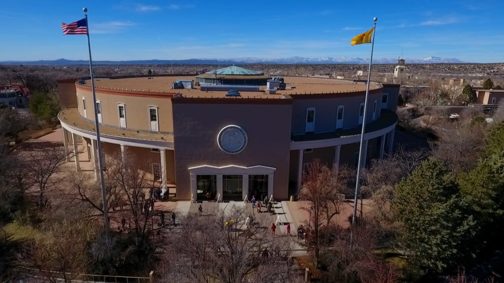 An aerial view of a building with flags flying over it.