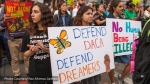 A group of people holding signs that say defend ddaa defend dreamers.