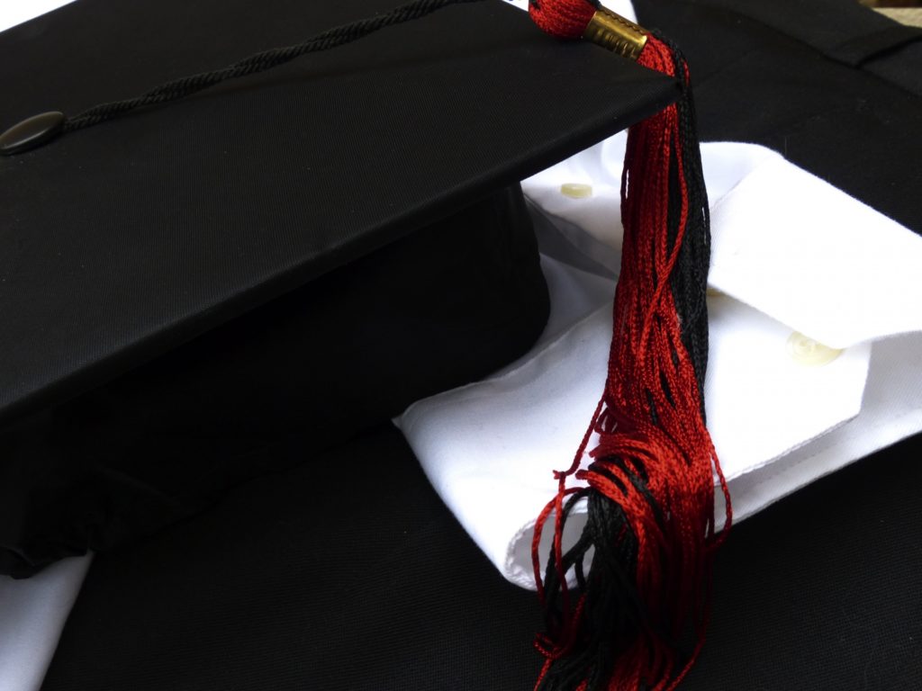 A black graduation cap with a red tassel.