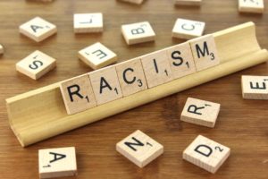 The word racism is spelled out on a wooden board.