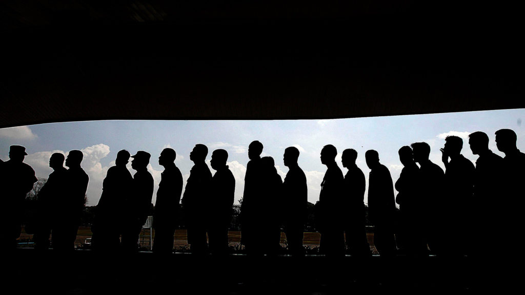 Silhouettes of men standing in a line.