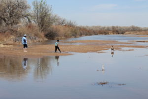 A group of people are standing in a muddy area.