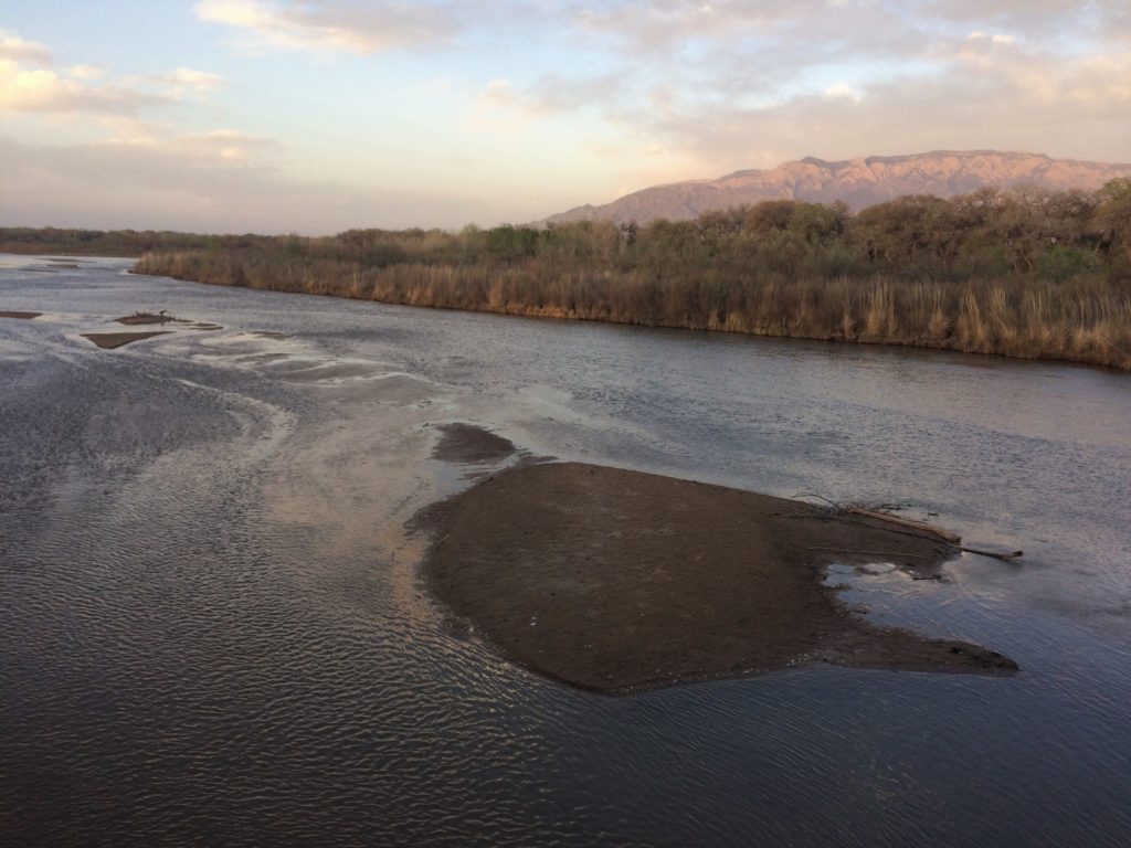 An aerial view of a river with mountains in the background.