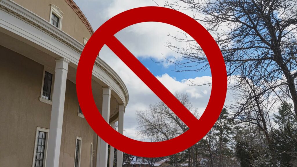 Composite of a no symbol in front of exterior view of the Santa Fe Roundhouse.