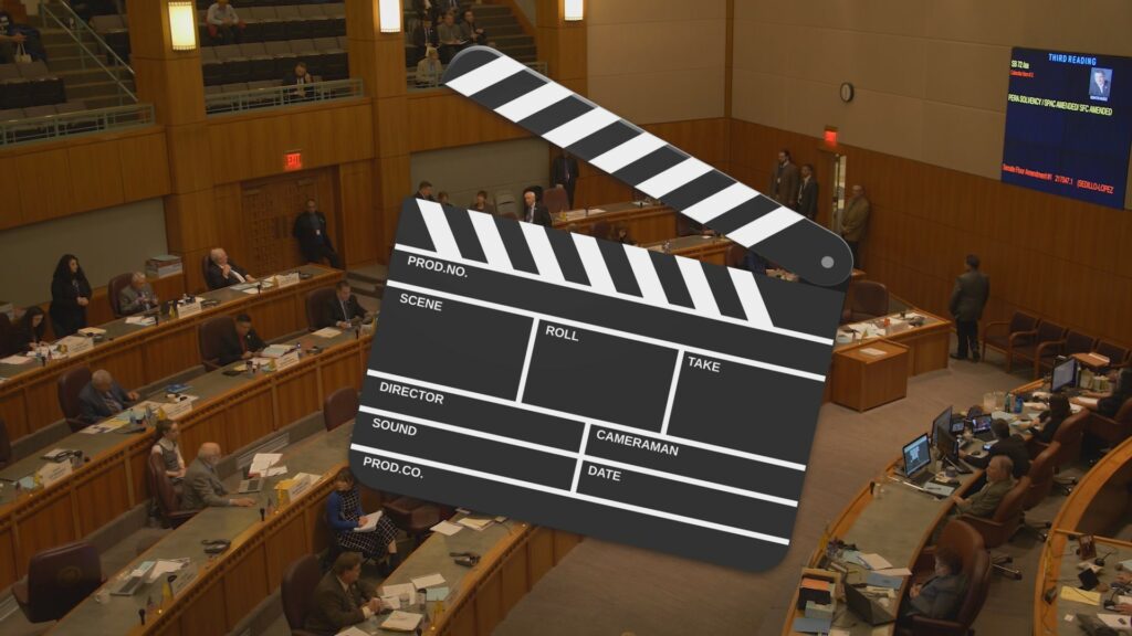 Composite of a film clapperboard in front of the Santa Fe Roundhouse interior.