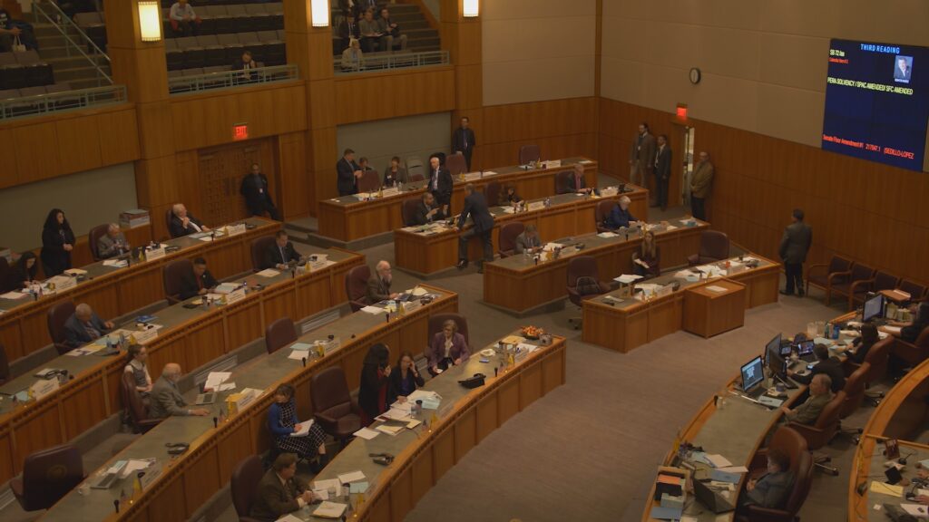 Interior view of the Santa Fe Roundhouse chambers, with lawmakers at work at their desks.