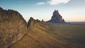 Wide view of a volcanic plug in the middle of desert.