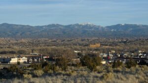 View from afar of a town's main road, with a mountain range in the distance.