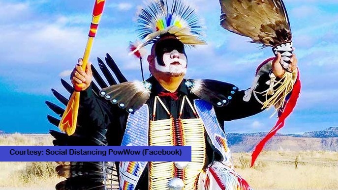 An Indigenous dancer performs, with text "Social Distancing PowWow".