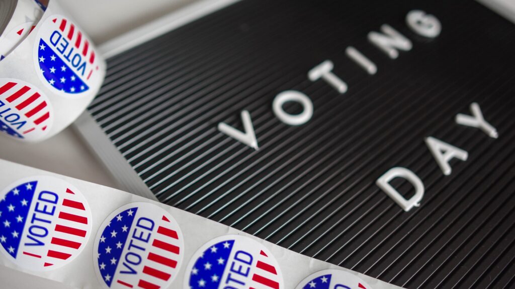 "I VOTED" stickers next to a sign reading "VOTING DAY".