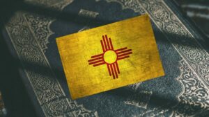 Composite of the New Mexico flag on top of a copy of the Qur'an.