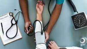 A nurse gauges the blood pressure of another person.