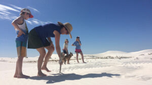 A family stands in the middle of White Sands National Park.
