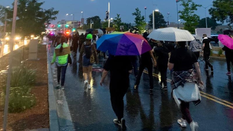 A group of demonstrators march during a rainstorm.