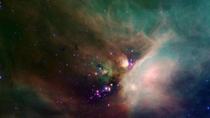 Stars peek out from a blanket of cosmic dust in outer space.