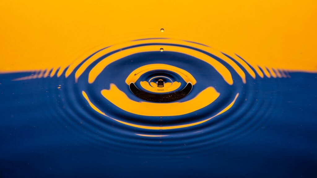 A small splash in a body of water, colored yellow and blue.