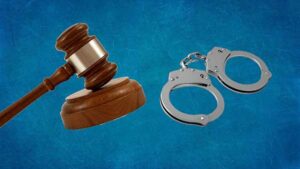 Composite of a gavel, and a pair of handcuffs.
