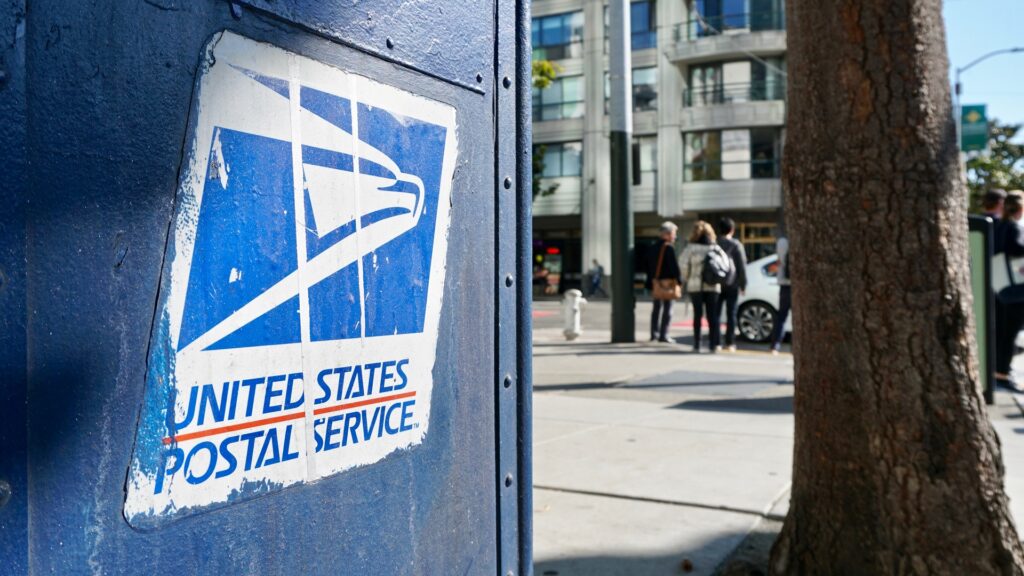 Close-up of a USPS mailbox on a city street.