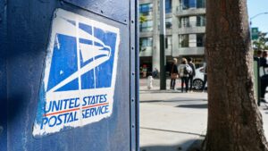 Close-up of a USPS mailbox on a city street.