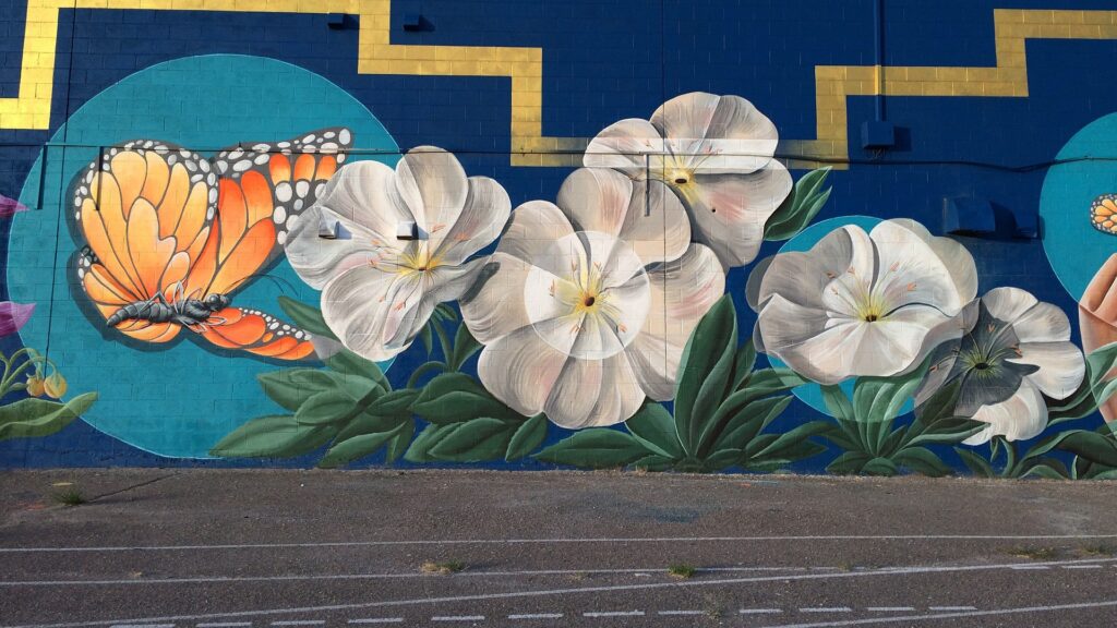 A mural featuring a Monarch butterfly and five white flowers.