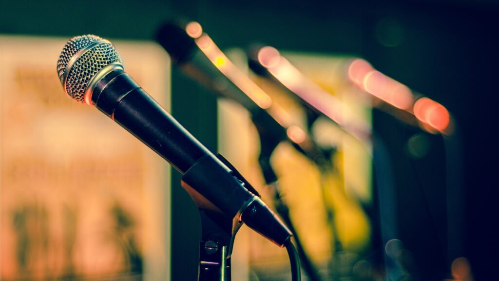 Close-up of a microphone, stood against other microphones.